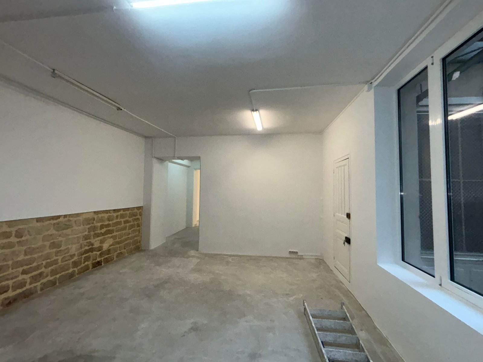 Pièce rénovée avec mur en pierre apparent dans un local professionnel